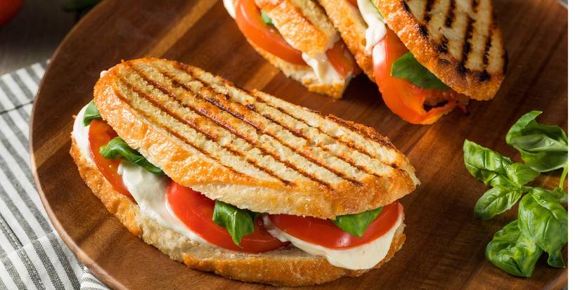A grilled basil mozzarella caprese panini sandwich