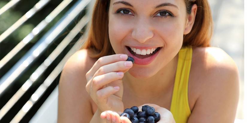 A woman eating blueberries