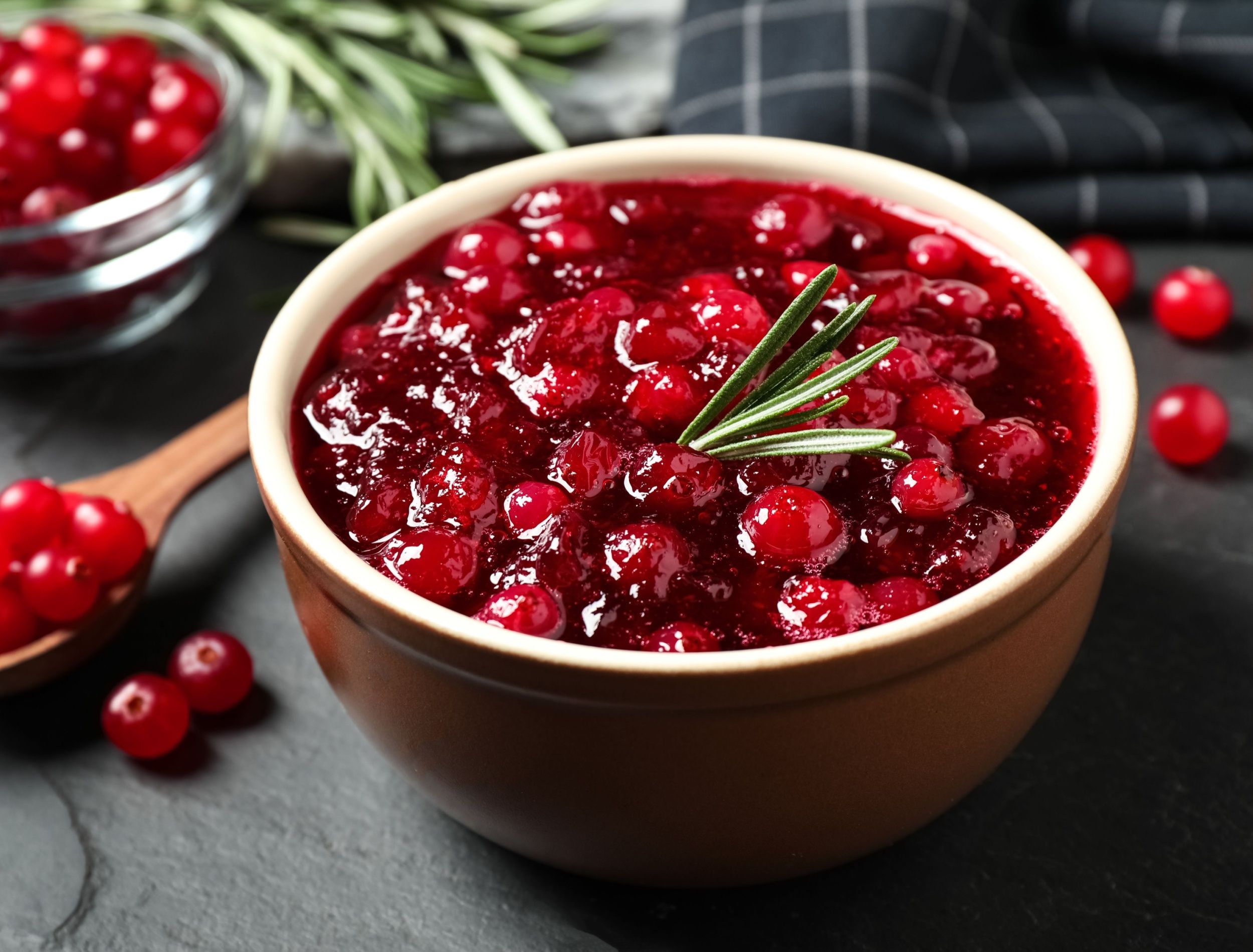 Bowl of fresh cranberry sauce with a sprig of rosemary