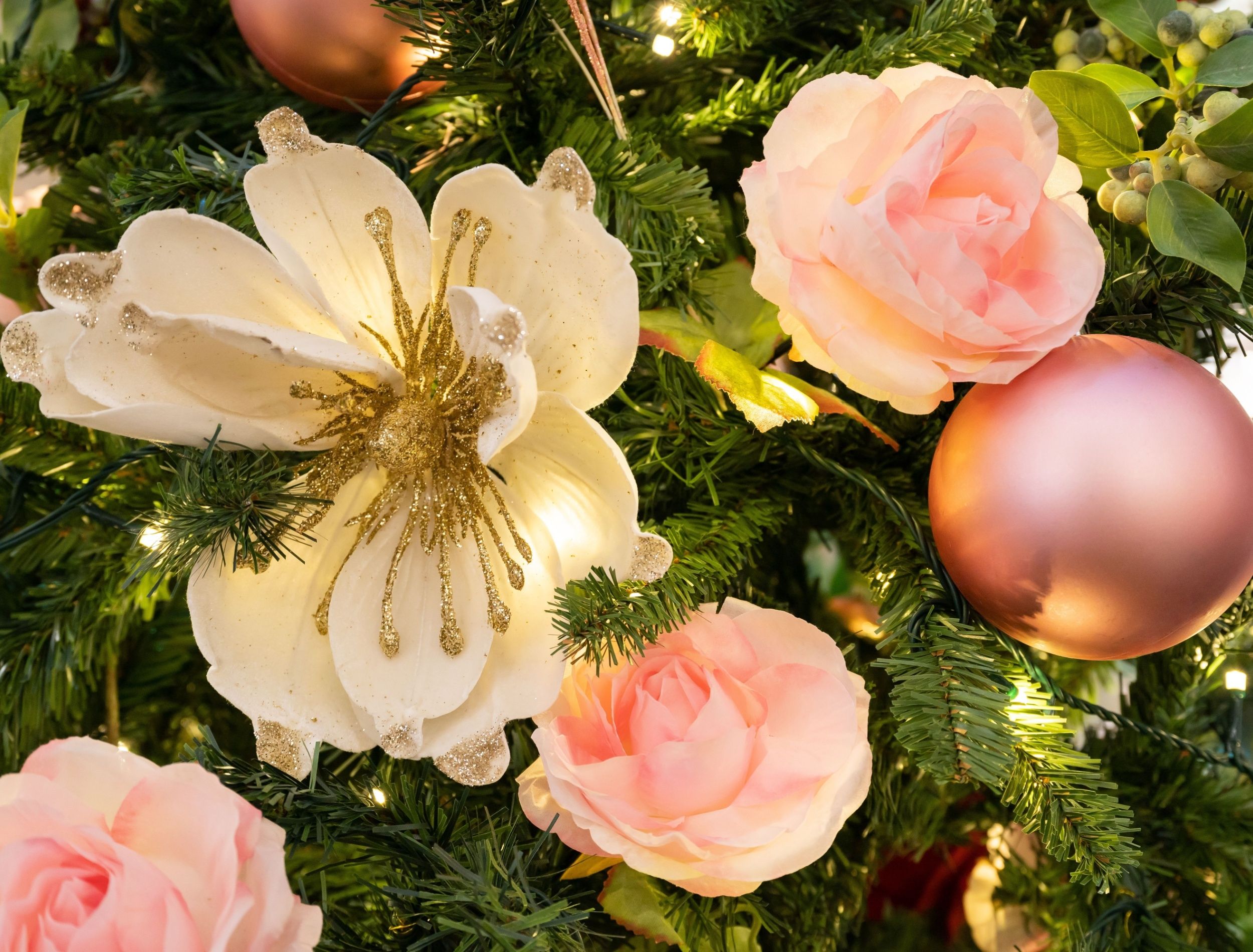 Pale pink flowers decorating a Christmas tree 